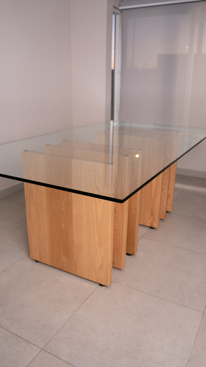 Mesa de comedor Mykonos, cubierta de vidrio sobre base de listones de madera, vista completa.