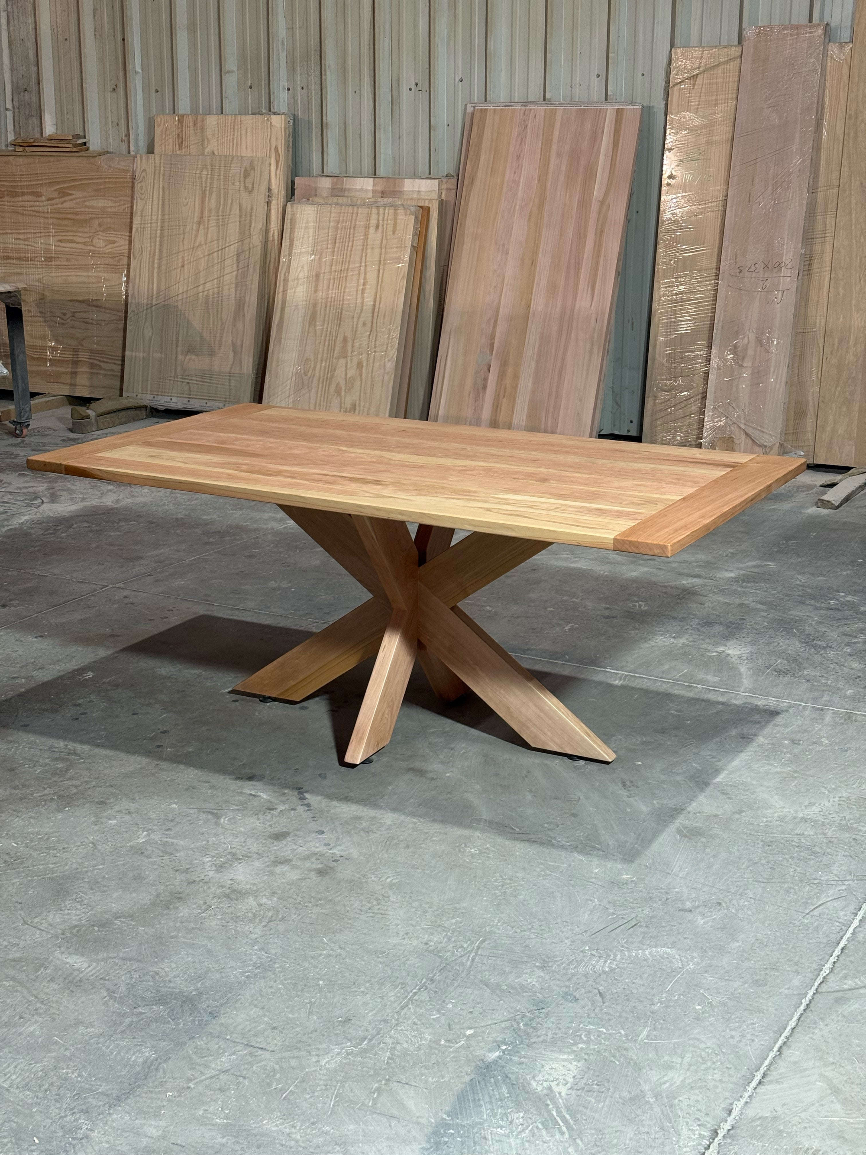 Mesa de comedor rectangular Lena en lenga natural de 170x90 cm, vista en tres cuartos con la cubierta y la base central completas, en el taller de Santino Design.
