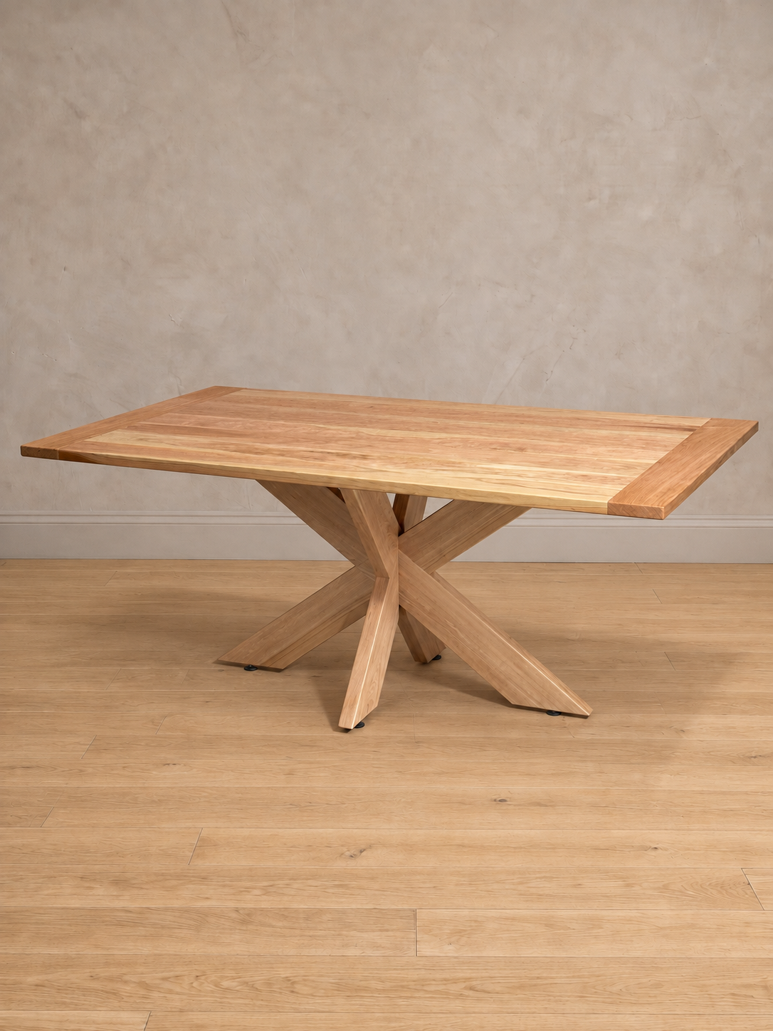 Mesa de comedor rectangular Lena en lenga natural, vista en tres cuartos, base de patas cruzadas de madera maciza.
