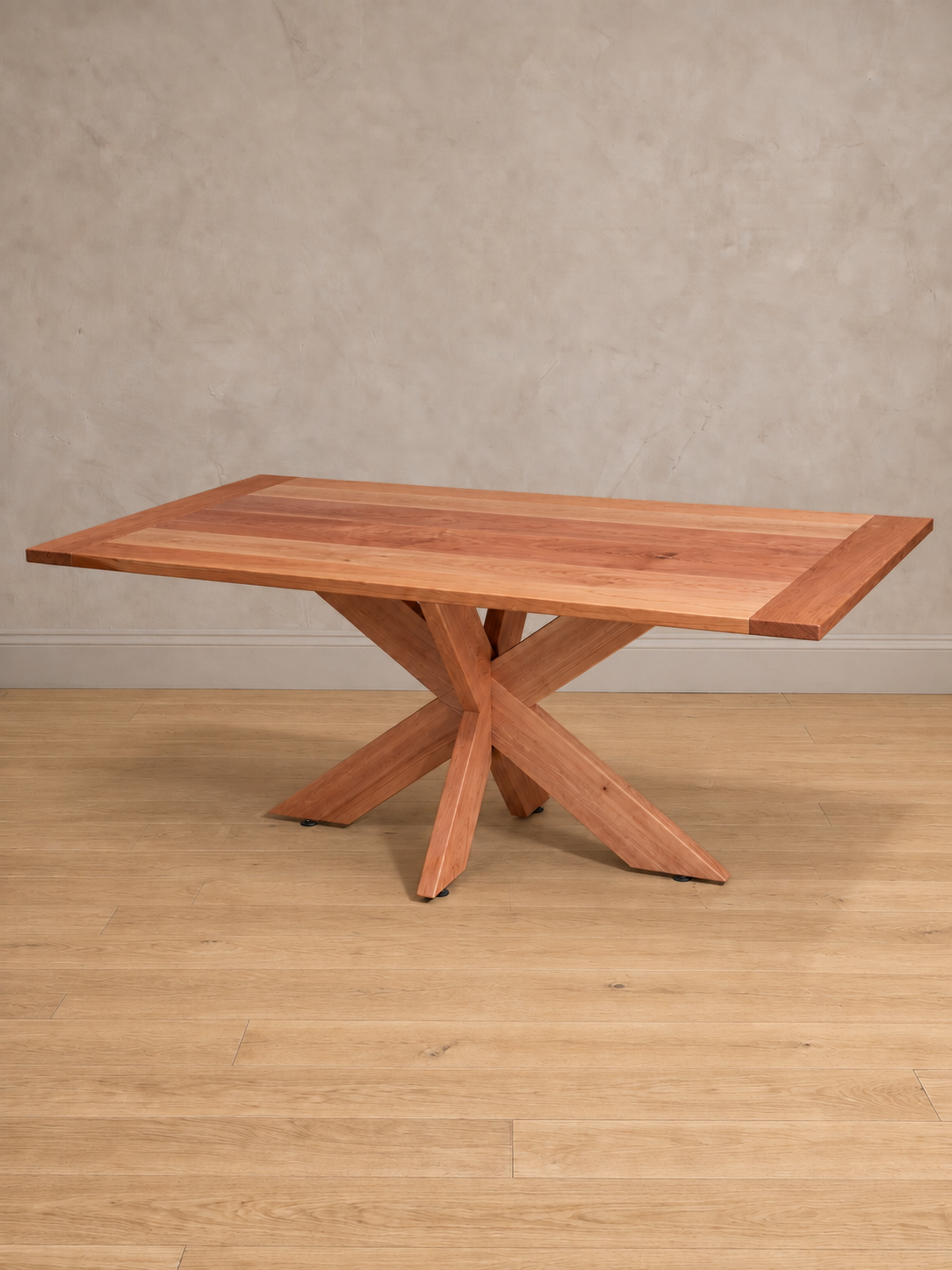 Mesa de comedor rectangular Lena en roble hualle natural, vista en tres cuartos, base de patas cruzadas de madera maciza.