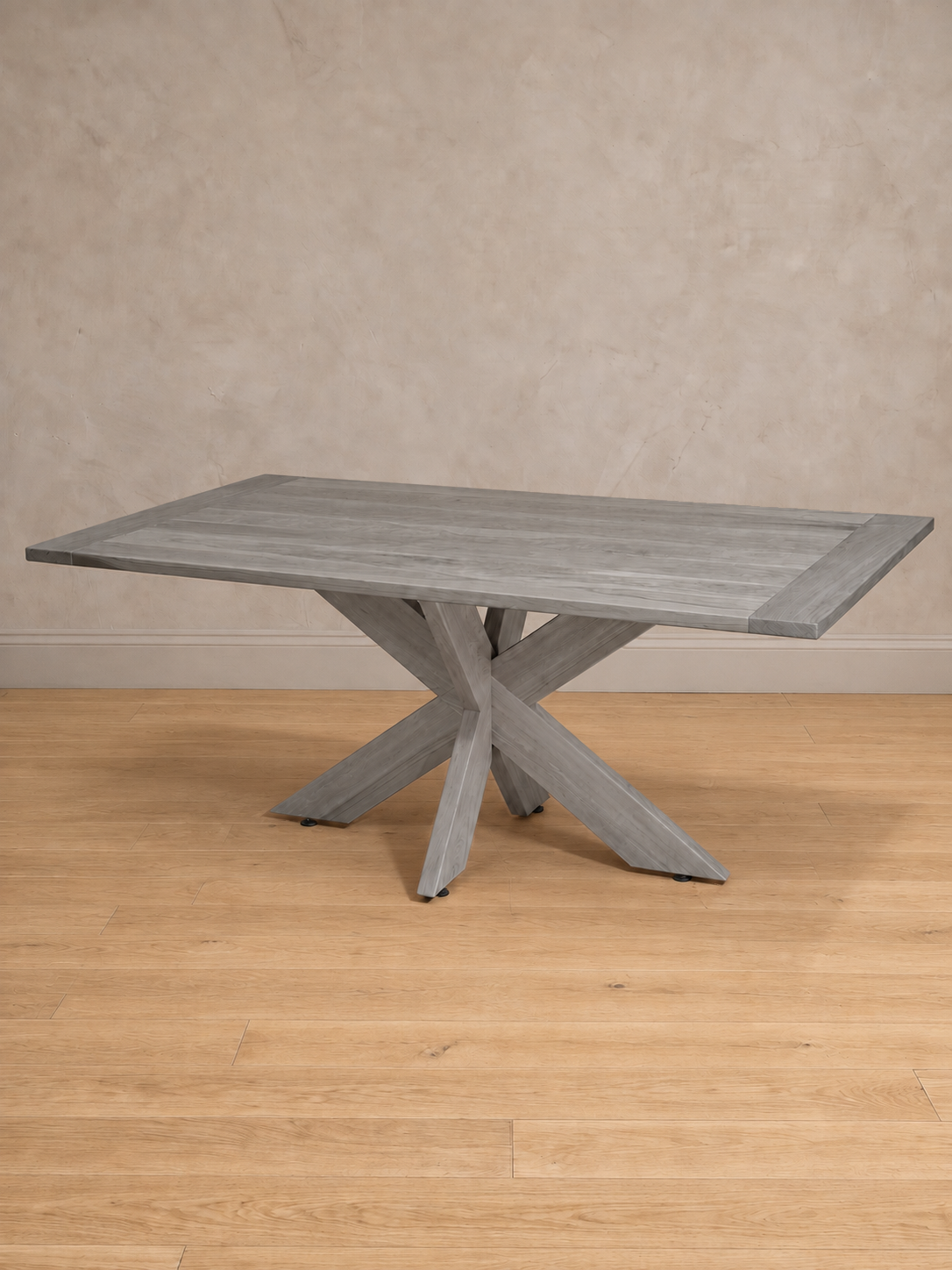 Mesa de comedor rectangular Lena en tono gris, vista en tres cuartos, base de patas cruzadas con la veta de la madera a la vista.