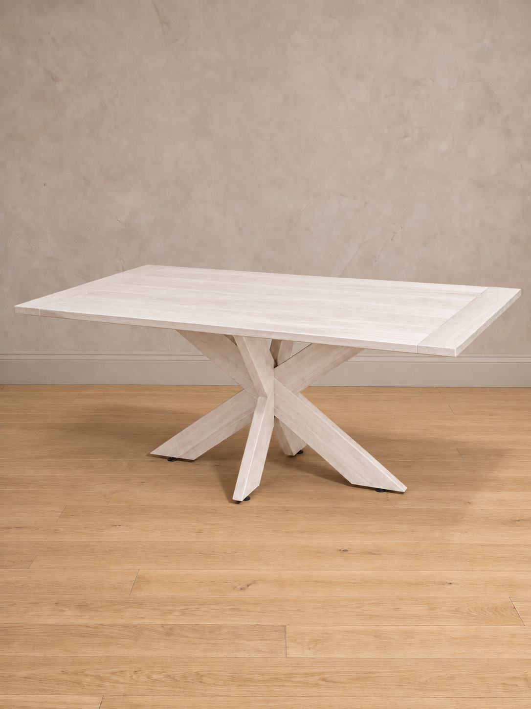 Mesa de comedor rectangular Lena en tono blanco, vista en tres cuartos, base de patas cruzadas con la veta de la madera a la vista.