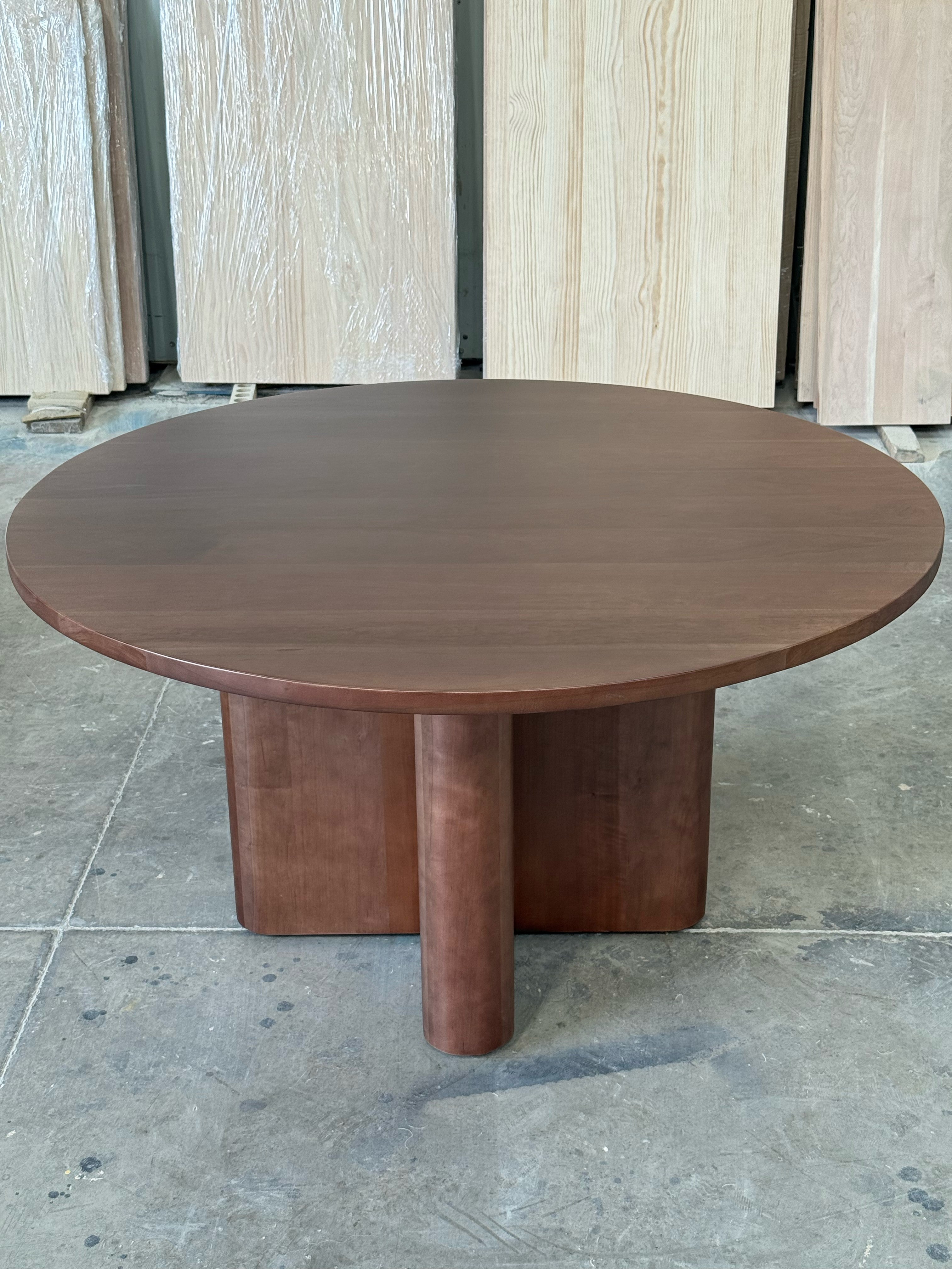 Mesa de comedor redonda Amora en lenga tono nogal vista completa desde arriba, cubierta redonda de 140 cm de diámetro.