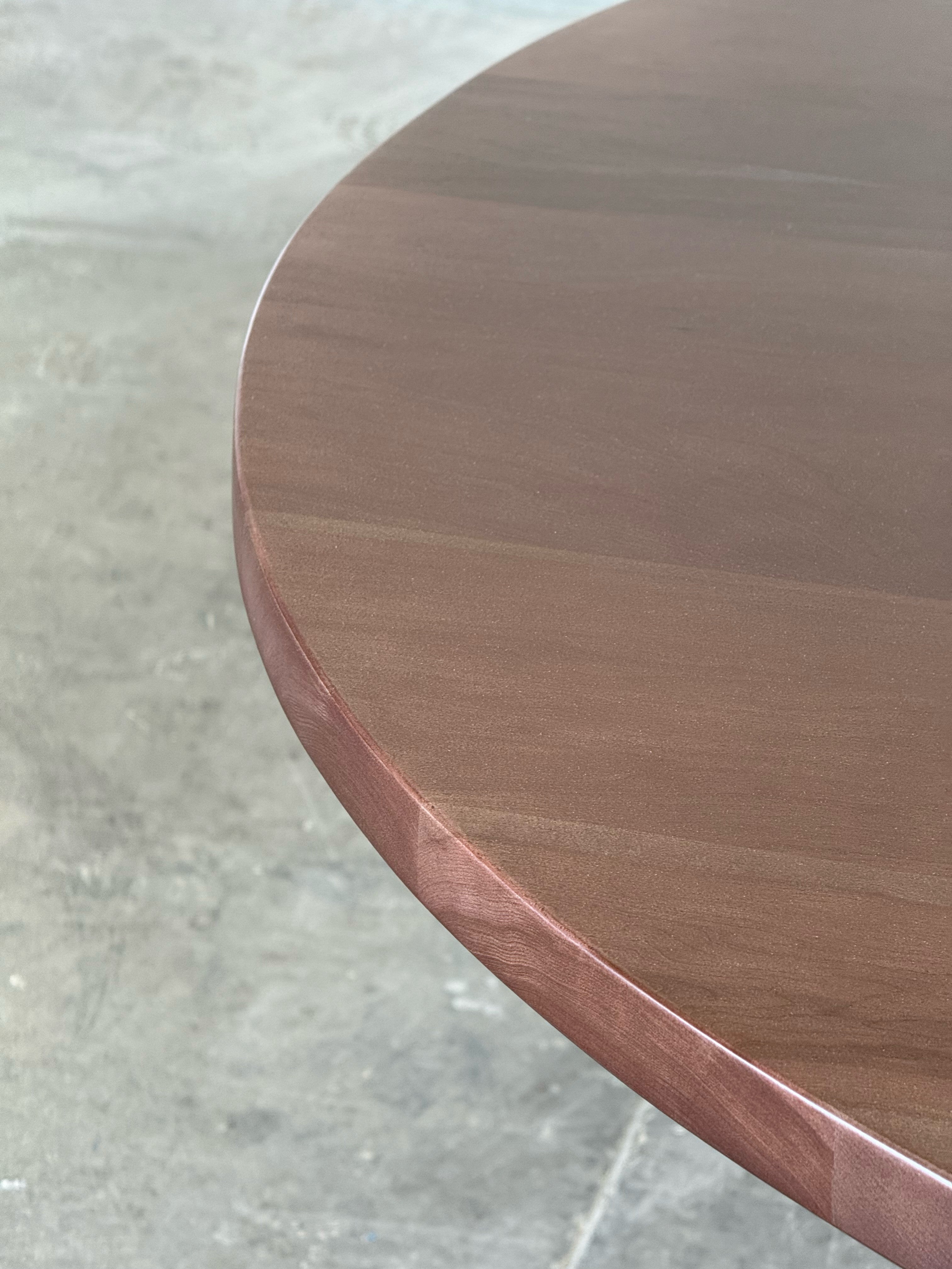 Canto de la cubierta de madera maciza de la mesa de comedor redonda Amora.