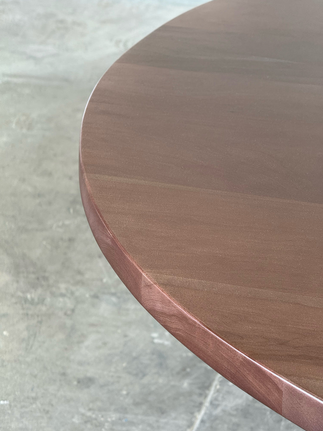 Canto de la cubierta de madera maciza de la mesa de comedor redonda Amora.